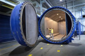 An AGNORA employee stands in front of the Autoclave to give perspective on the size