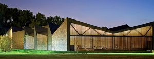 Exterior shot of WMS Boathouse at Clark Park, Chicago featuring Interior shot of rowing team training in gym facility in front of Oversized, daylighting insulated glass units.