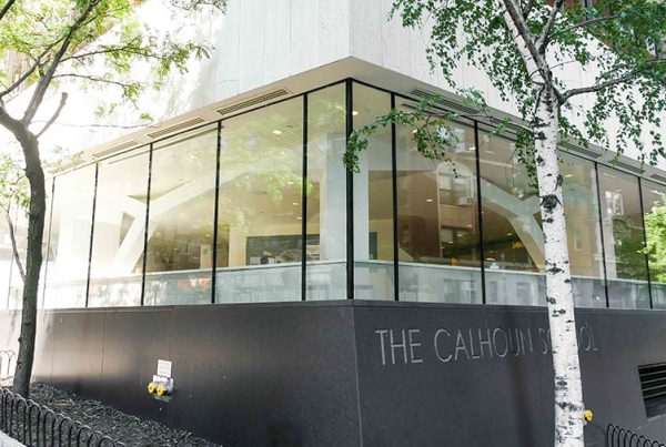 Exterior shot, corner view of the Calhoun School featuring laminated glass units and green opacicoat for the school’s entrance.