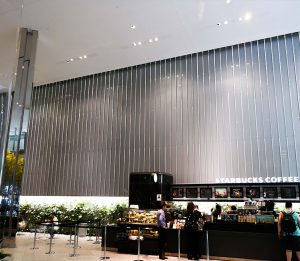 Inside BlackRock's office tower, a view of starbucks cafe and behind, the oversize laminate panels