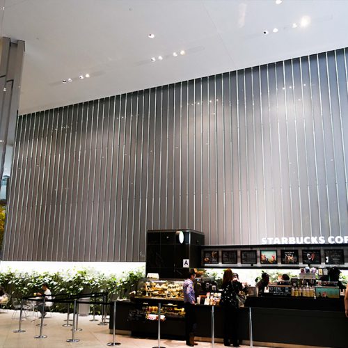 Inside BlackRock's office tower, a view of starbucks cafe and behind, the oversize laminate panels