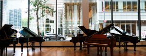 Inside Steinway & Sons looking at grand pianos and insulated glass units consisting of low-iron and low-e glass